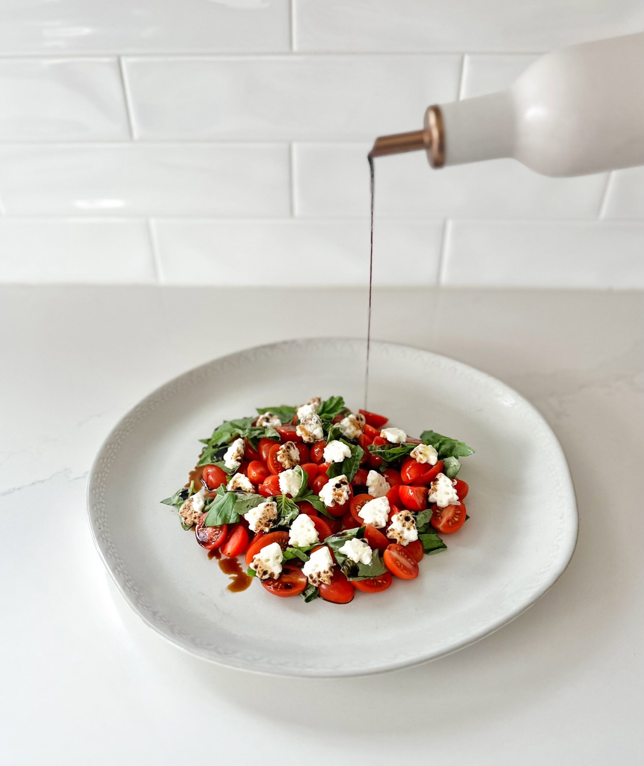 drizzling balsamic on caprese salad 