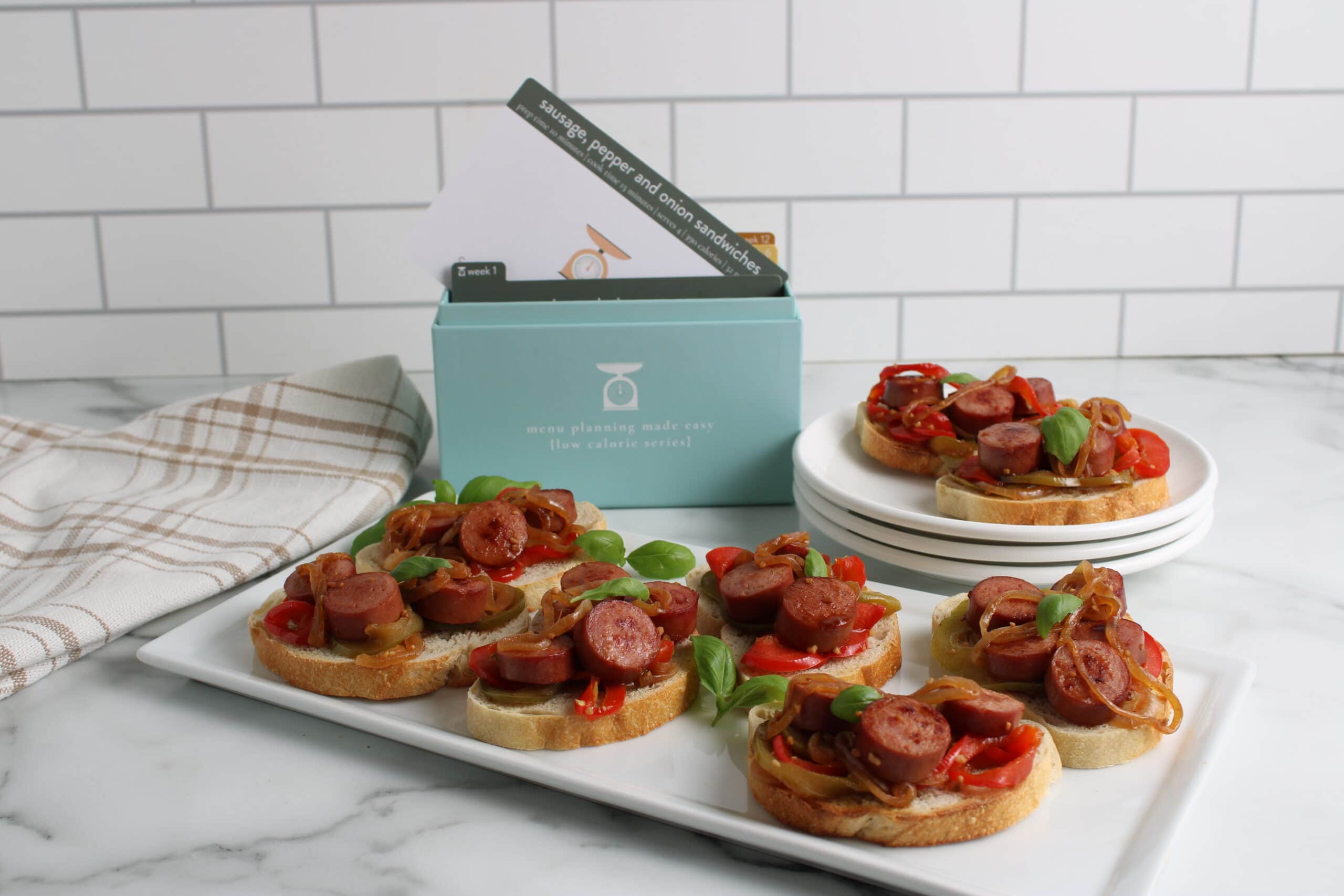 Sausage, Pepper, & Onion Sandwiches on plates with menu box