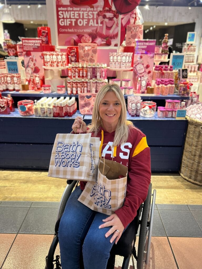 person holding Bath and body works shopping bags in store