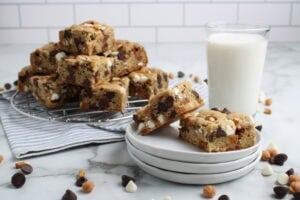 Everything But The Kitchen Sink Cookie Bars on Counter with Glass of Milk