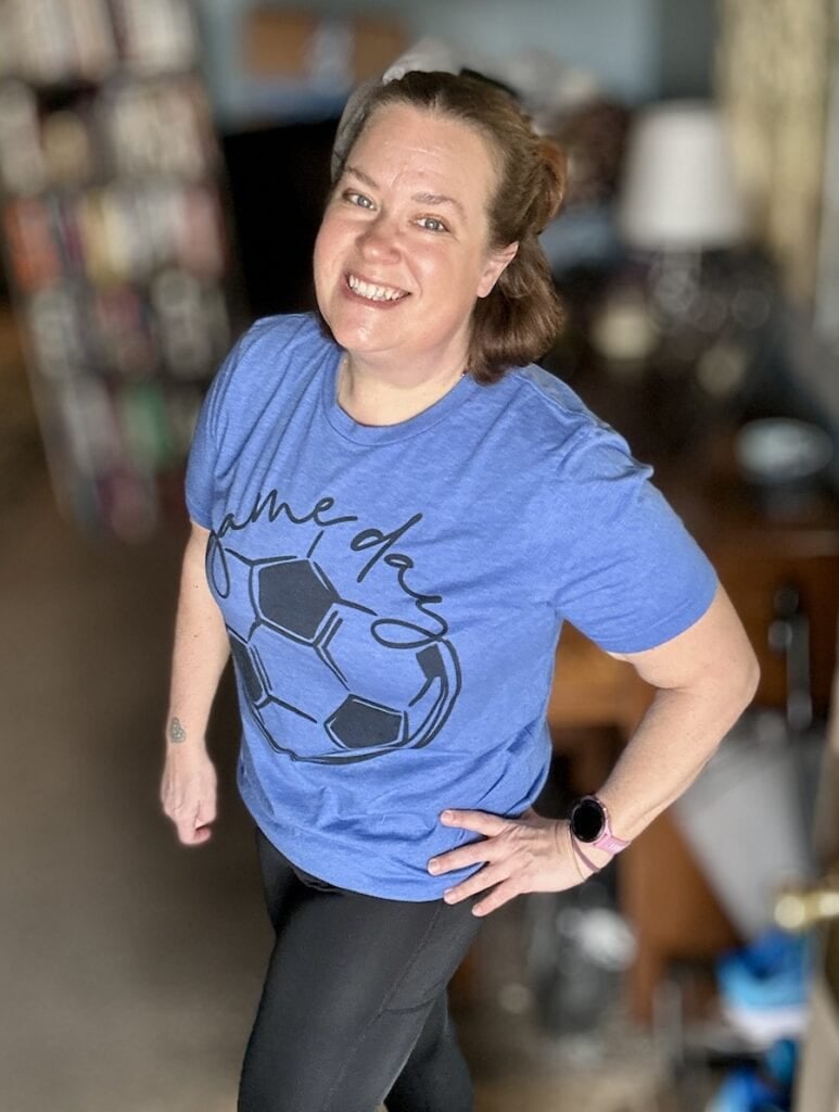 blue game day soccer tee being worn by woman in black leggings