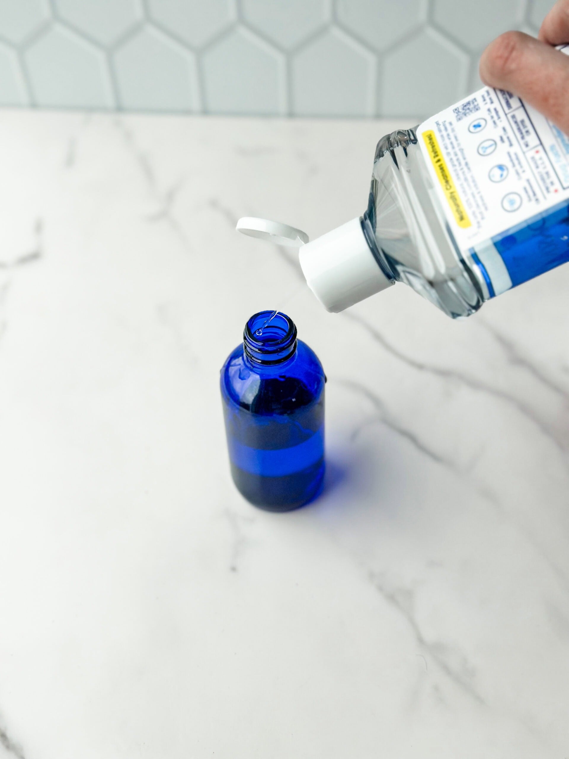 adding witch hazel to glass blue bottle