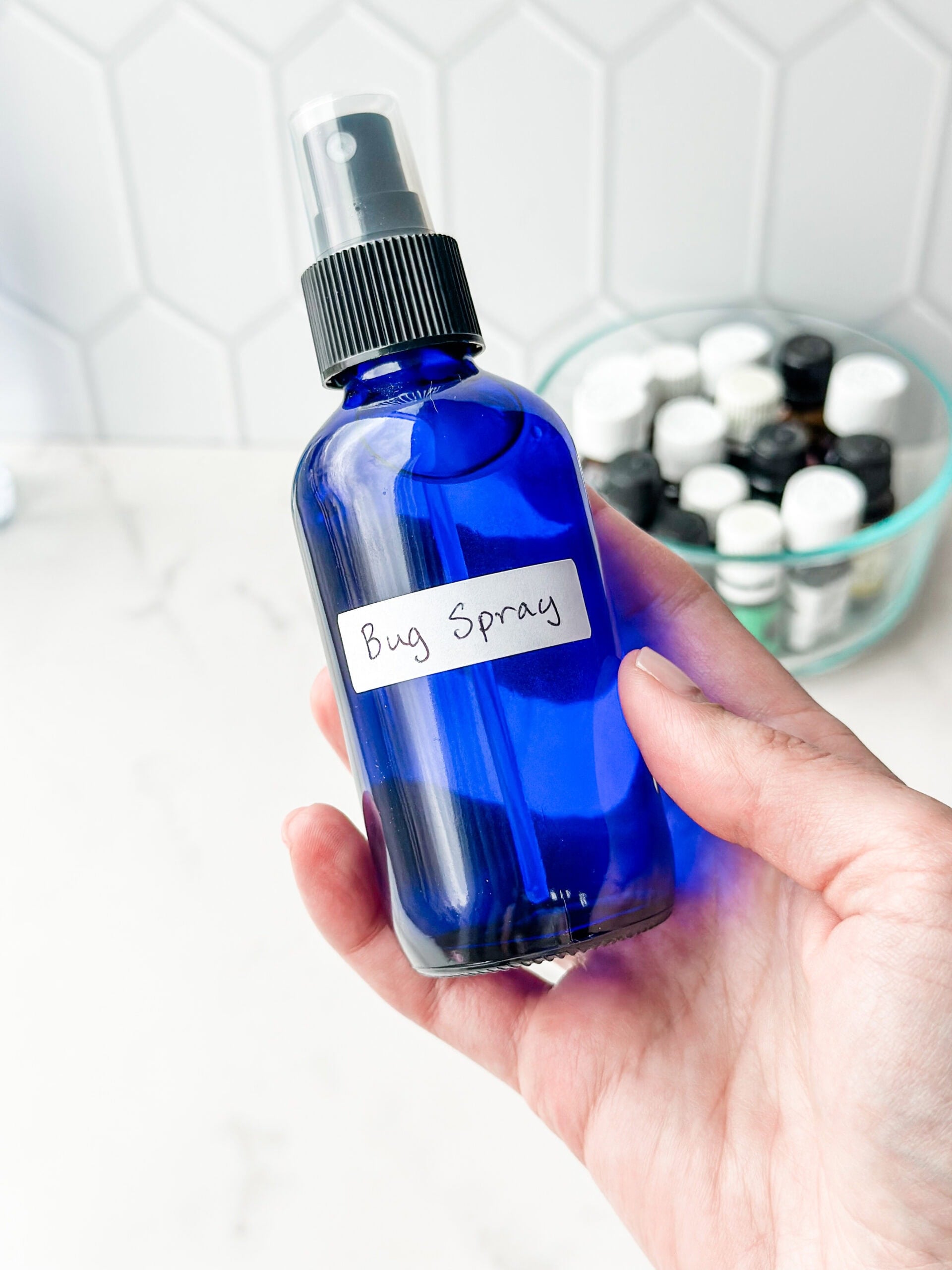 homemade bug spray in blue glass bottle