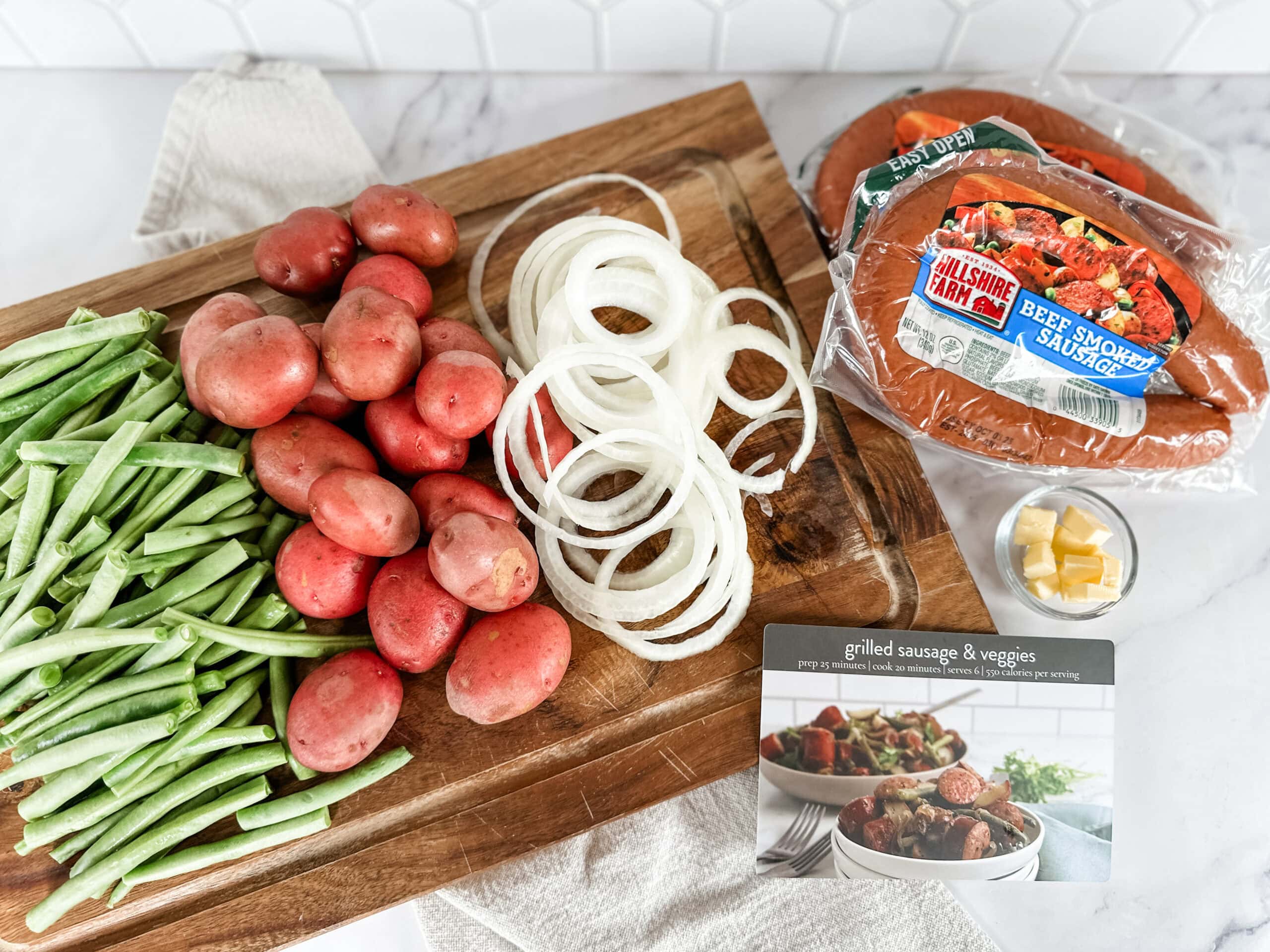 grilled sausage and veggies ingredients on countertop 