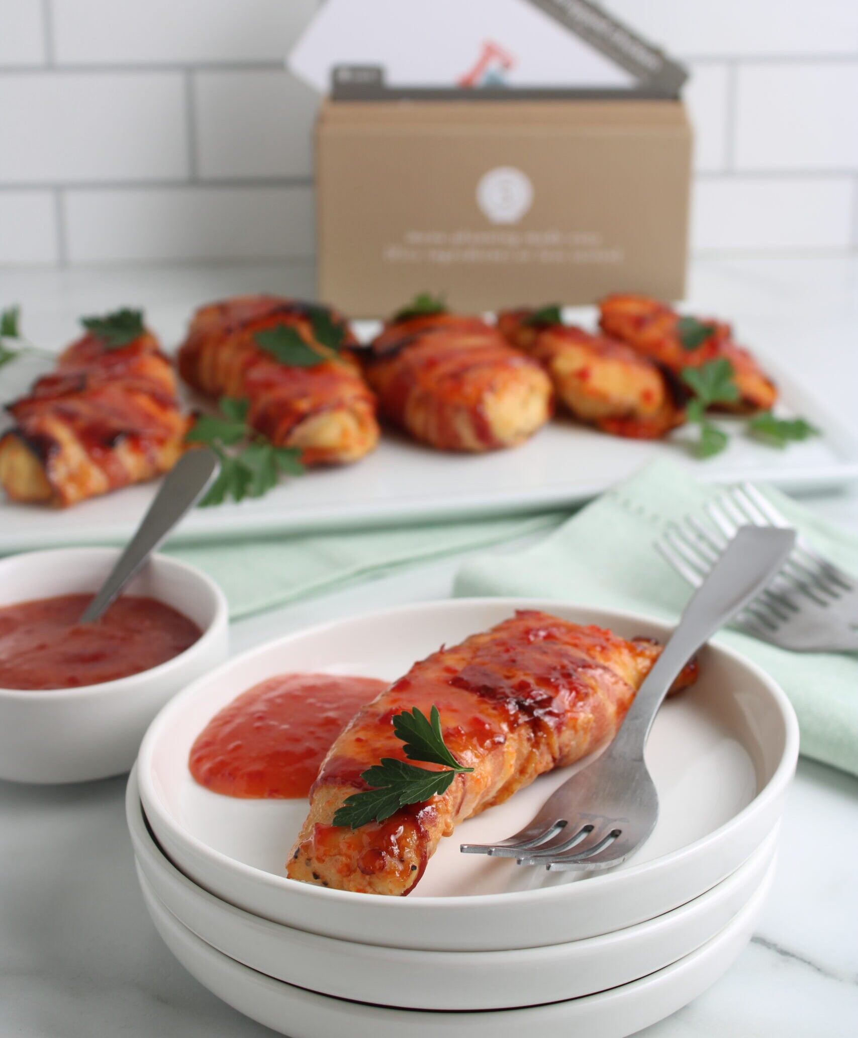 bacon pepper jelly chicken on plate with recipe box and platter in background