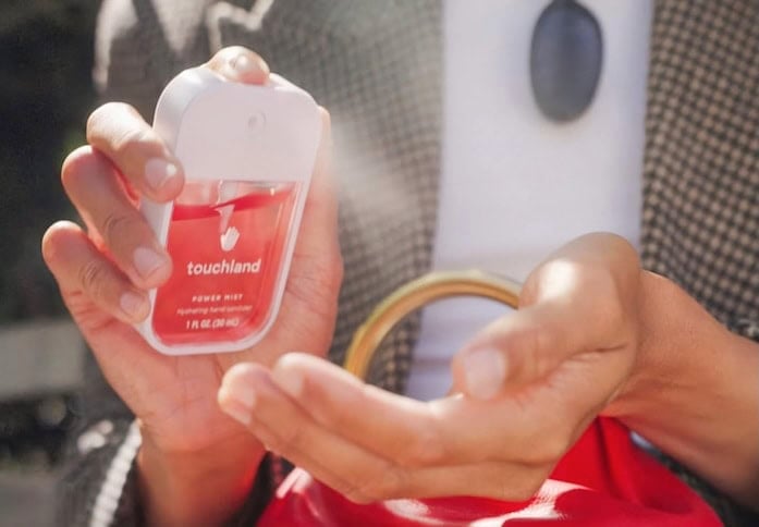 person using Touchland spray