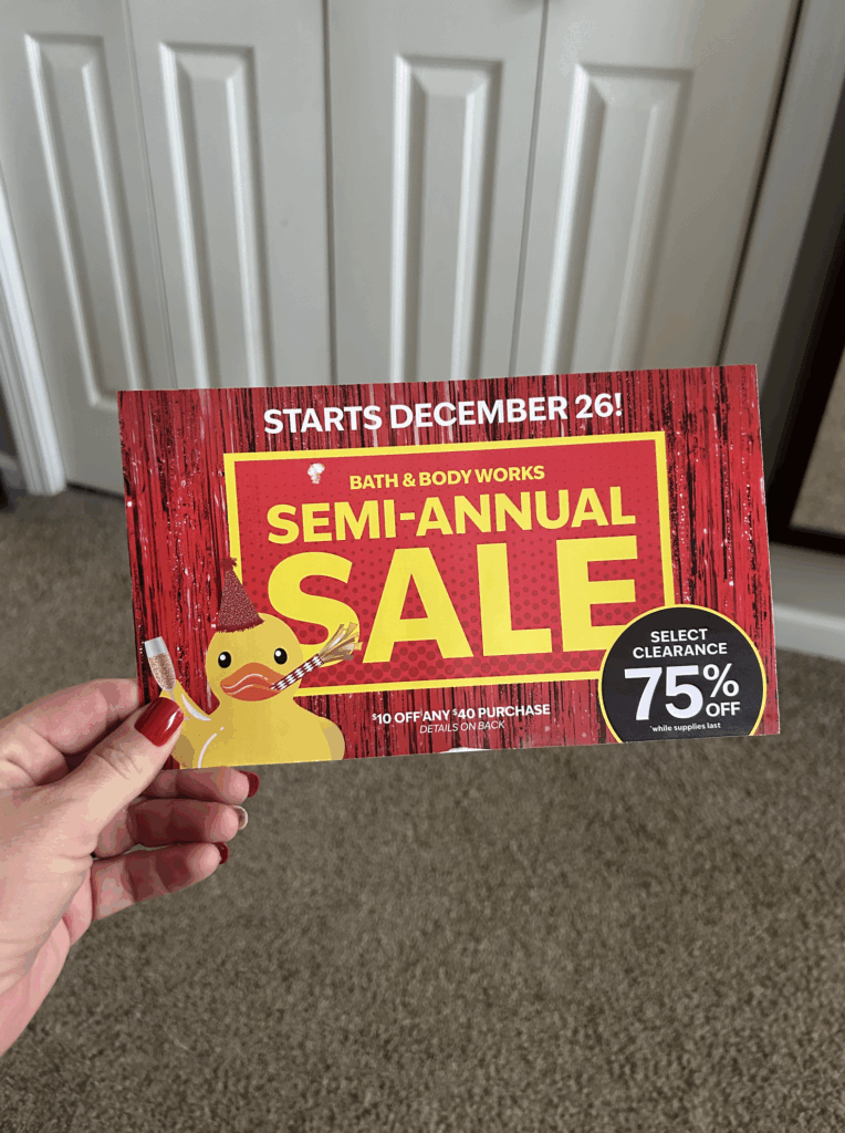 hand holding bath body works mailer coupon