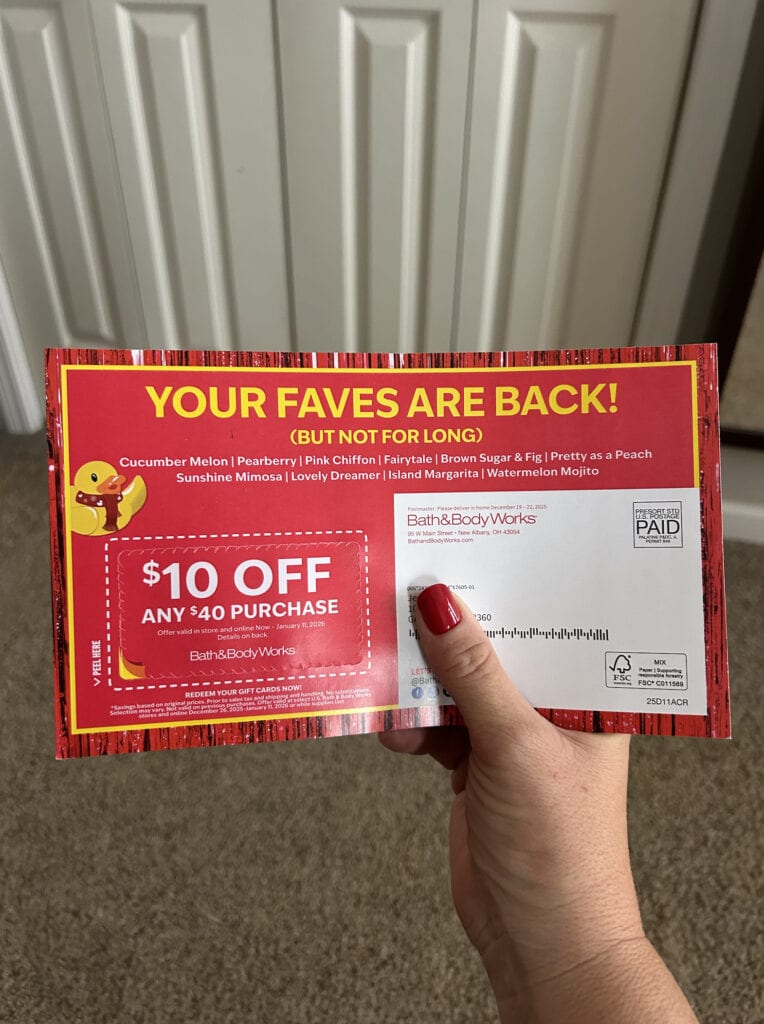 hand holding bath body works mailer coupon