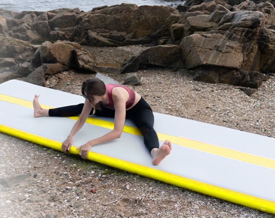 woman stretching on gym mat on beach