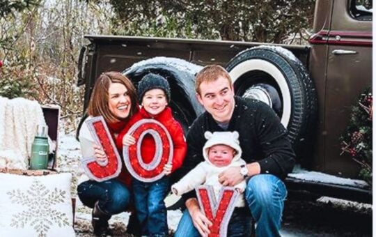 woman man and 2 kids holding up J O Y letters outside
