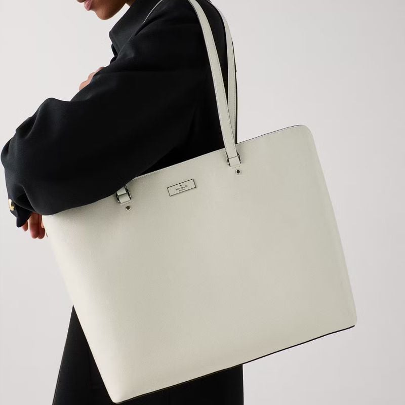 woman carrying white kate spade tote