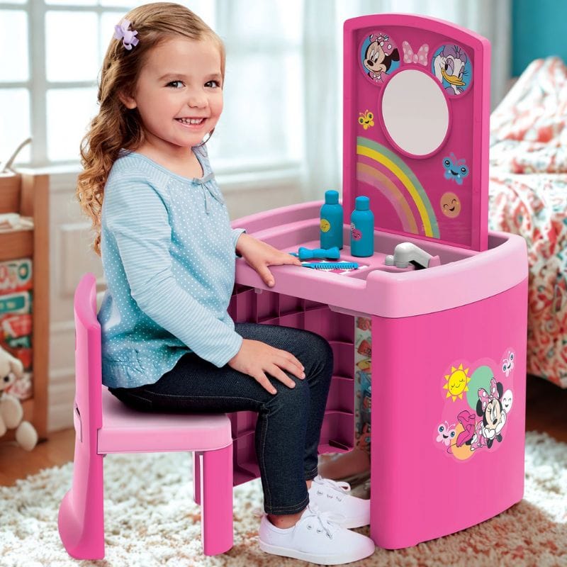 little girl sitting at Disney play table