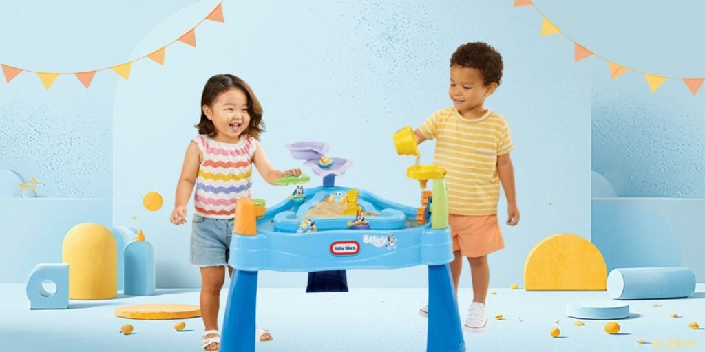girl and boy playing with water table