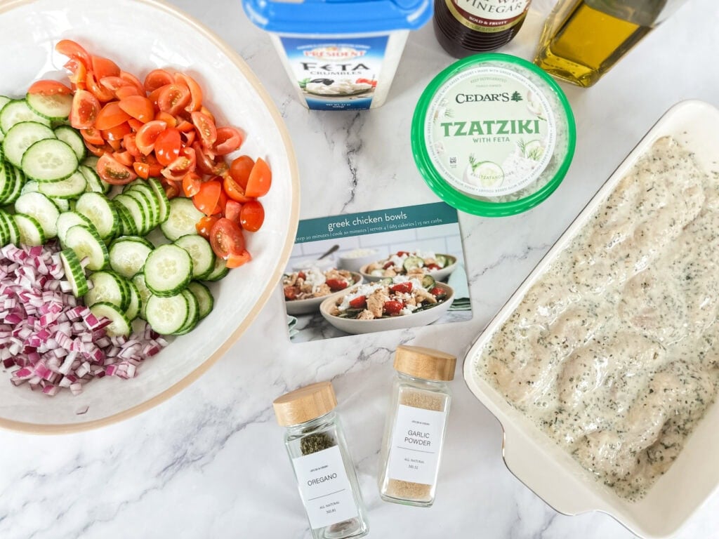 greek chicken bowls ingredients on counter with recipe card