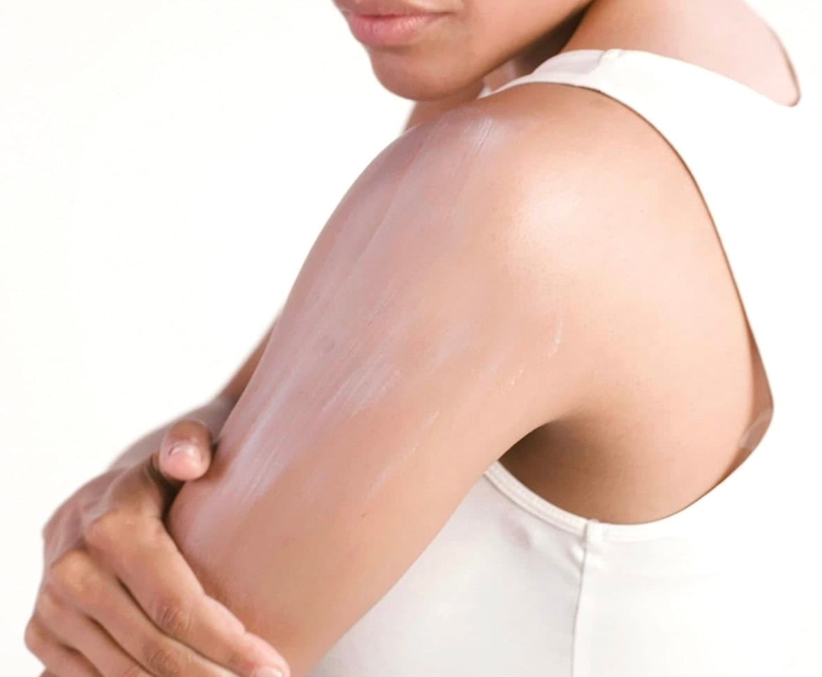 putting sunscreen on upper arm