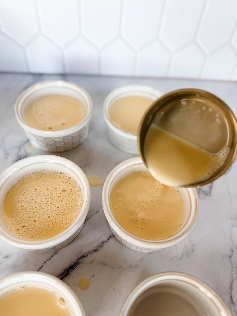 pouring Crème Brûlée mixture into white ramekins