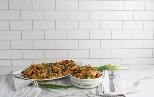 Kung Pao Chicken Noodle Bake on platter and plate with forks