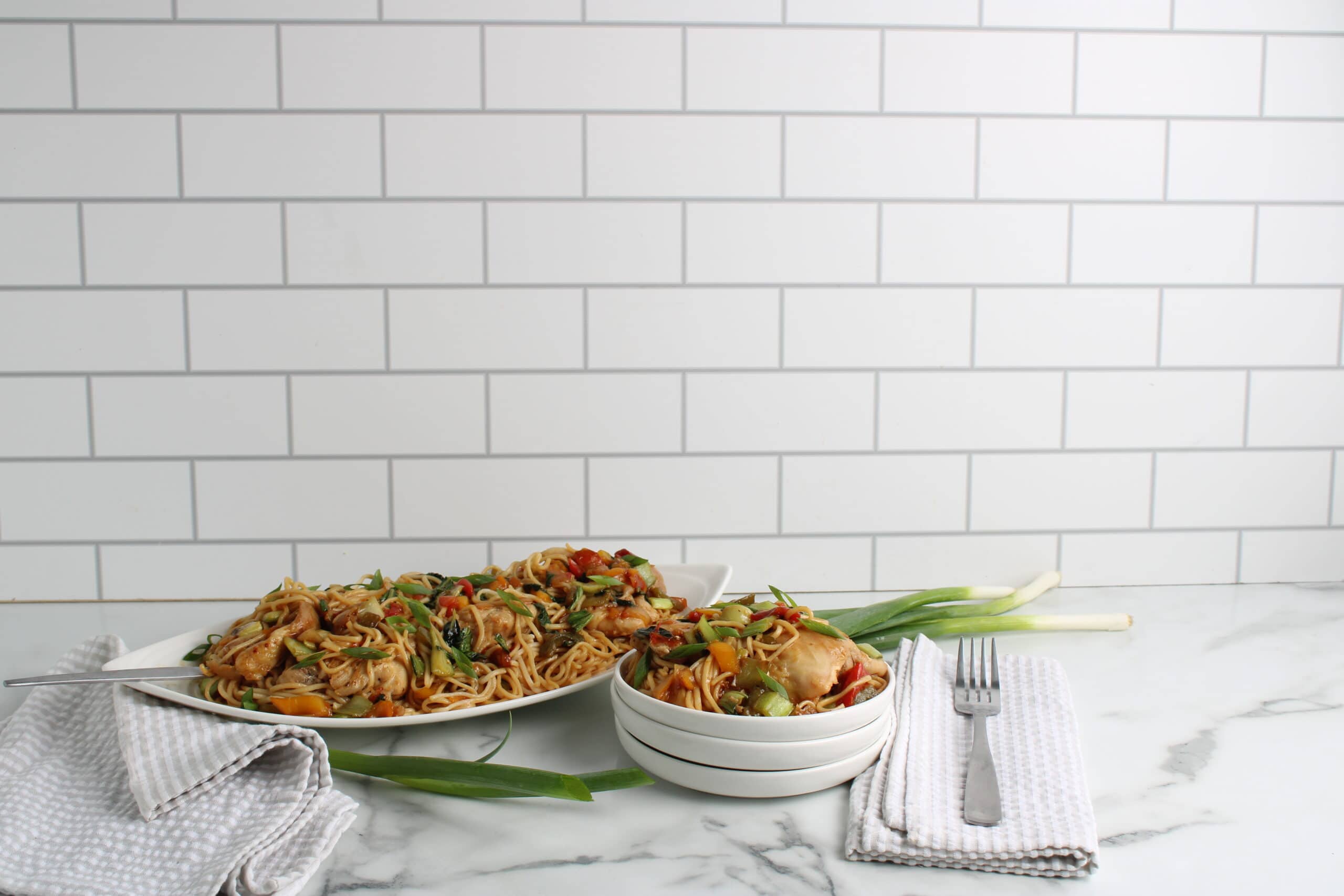 Kung Pao Chicken Noodle Bake on platter and plate with forks